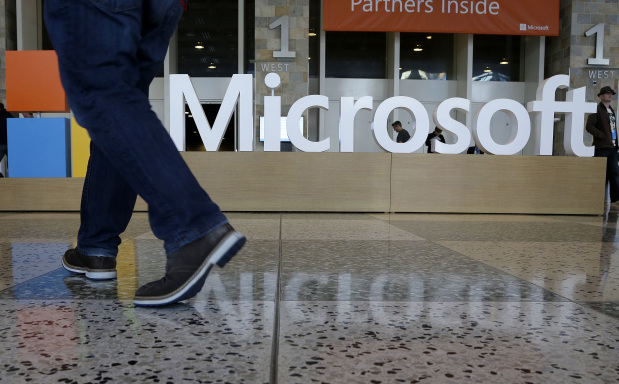 In this April 28, 2015 file photo, a man walks past a Microsoft sign set up for the Microsoft BUILD conference at Moscone Center in San Francisco. Starting next year, Microsoft will cut the free space it offers through its OneDrive service to 5 gigabytes, down from 15 gigabytes now. Microsoft says the new allotment is enough for about 6,600 Office documents or 1,600 photos. (AP File Photo) Data hogs force Microsoft to cut cloud storage